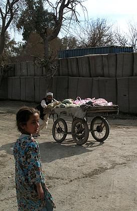 Afghan girl and old man pushing a cart