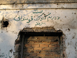 bullet and shell-scarred doorway bricked over