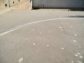 bullet-scarred bottom of empty swimming pool