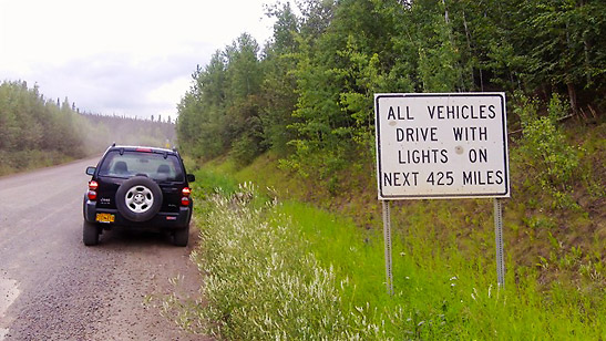 the writer's rented vehicle and road sign on Dalton Highway