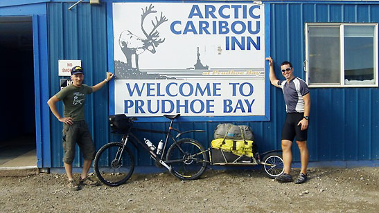 the writer and Frantz at a welcome sign in Prudhoe Bay
