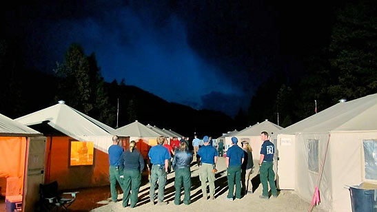 overhead team members observing thunderstorm at fire camp