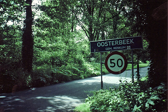 green foliage amidst sign on road leading to Oosterbeek, Holland near the Arnhem-Oosterbeek cemetery