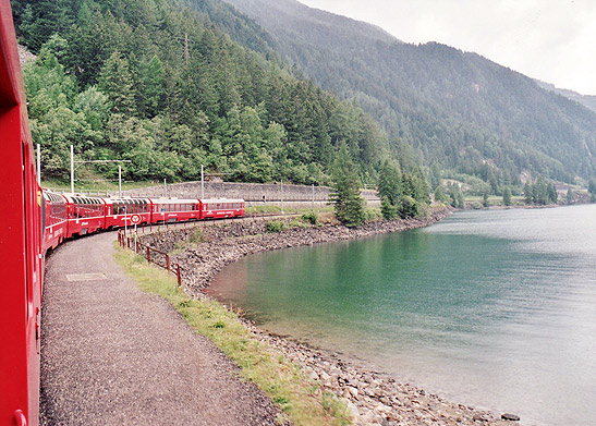 Bernina Express train passing by a lake, Switzerland