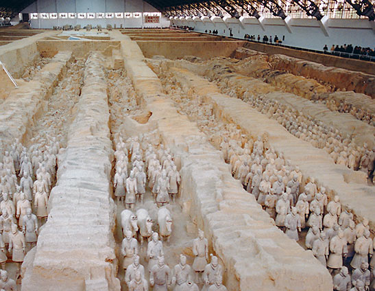 rows of restored terra cotta warriors at excavation site