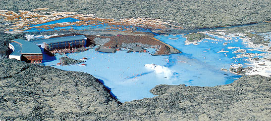 aerial view of the Blue Lagoon Geothermal Spa in the middle of a black lava field