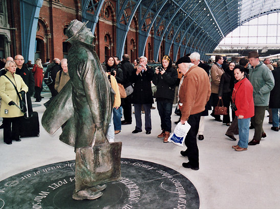 visitors around a sculpture of British poet Sir John Betjeman