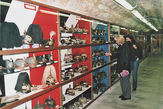 two women looking at a collection of World War 1 German helmets