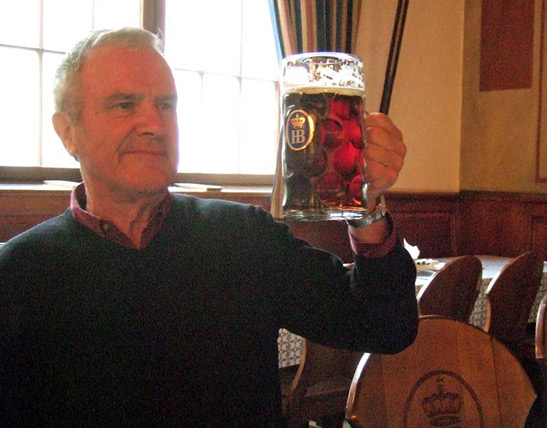 the writer holding a mug of German beer