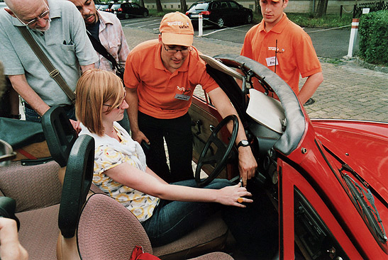 young German woman being given instructions on how to drive a Trabant