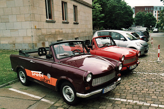 two Trabants among a line of cars at a parking lot