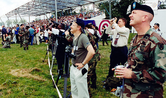 crowd gathered to watch parachute jump above St. Mere Eglise, Normandy on June 6, 2004