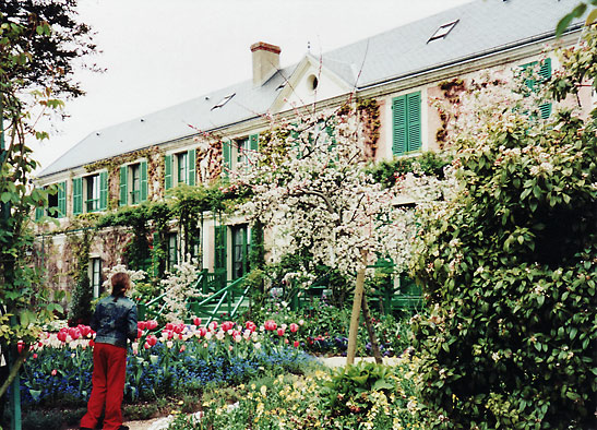 a garden of flowers with Monet's home in the background, Giverny, France