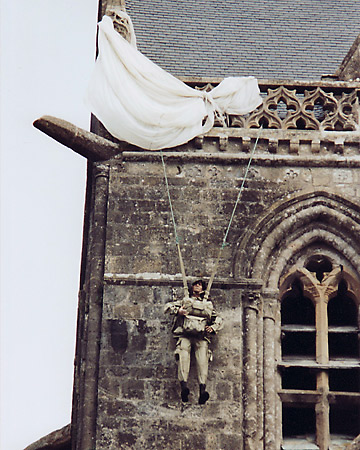 figure of WW2 American paratrooper John Steele hanging with his parachure on church steeple, St. Mere Eglise, Normandy, France