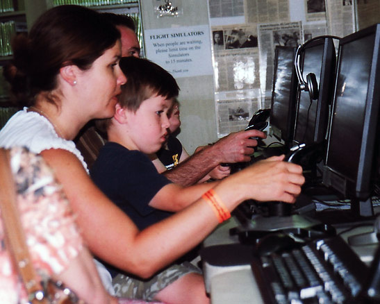 the writer's daughter and grandson enjoying aerial combat games on computers at the second floor of the Palm Springs Air Museum