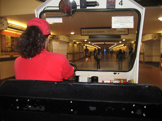 Monica on the controls of her vehicle, taking the writer to the Amtrak train platform at Union Station, Los Angeles