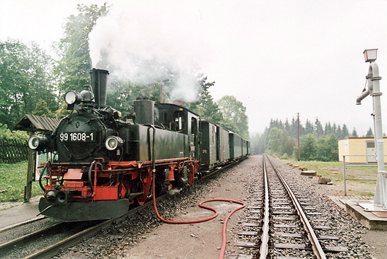 steam train taking in water for its engine