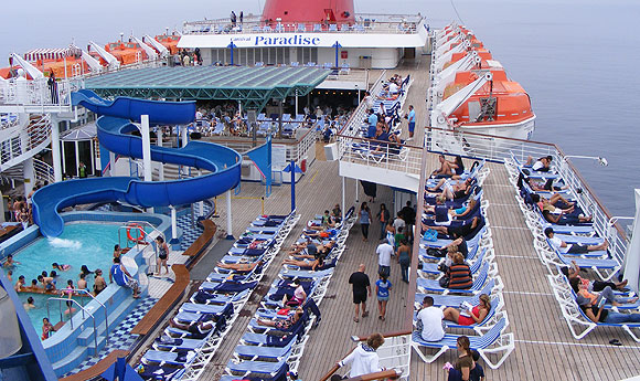 top deck showing swmming pool with slide and numerous recliners