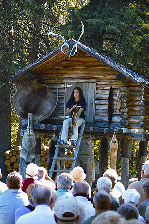 Native Alaskan tour guide showing visitors pelts from different animals hunted by her ancestors