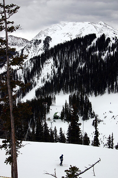 skiier at the Taos Ski Valley with snow-covered mountains in the background