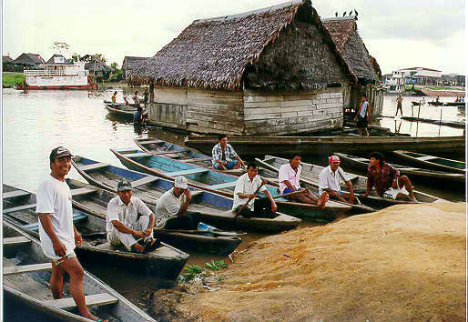 boats on riverbank with Iquitos houses on stilts and rafts in the background, Amazon River, Peru