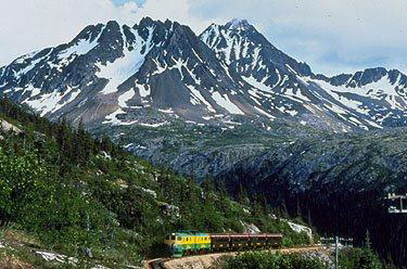 White Pass and Yukon River Railway train to Skagway passing through mountain wilderness