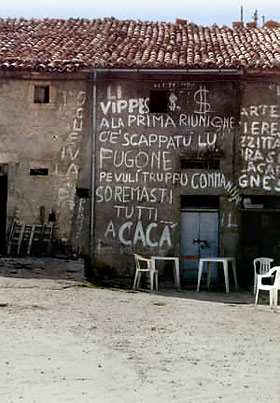 whitewashed graffiti at the front of an old wooden building