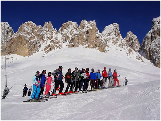 skiiers with the Dolomite peaks in the background