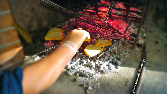 rustic bread grilling in a wood burning hearth