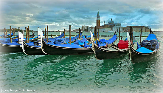 a row of gondolas at the Riva degli Schiavoni with the San Giorgio Maggiore in the background