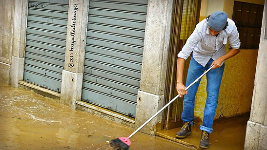 local resident clearing out water from the aqua alta