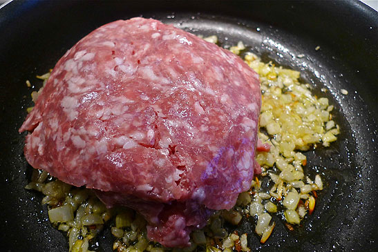 minced pork placed into onion-celery mixture